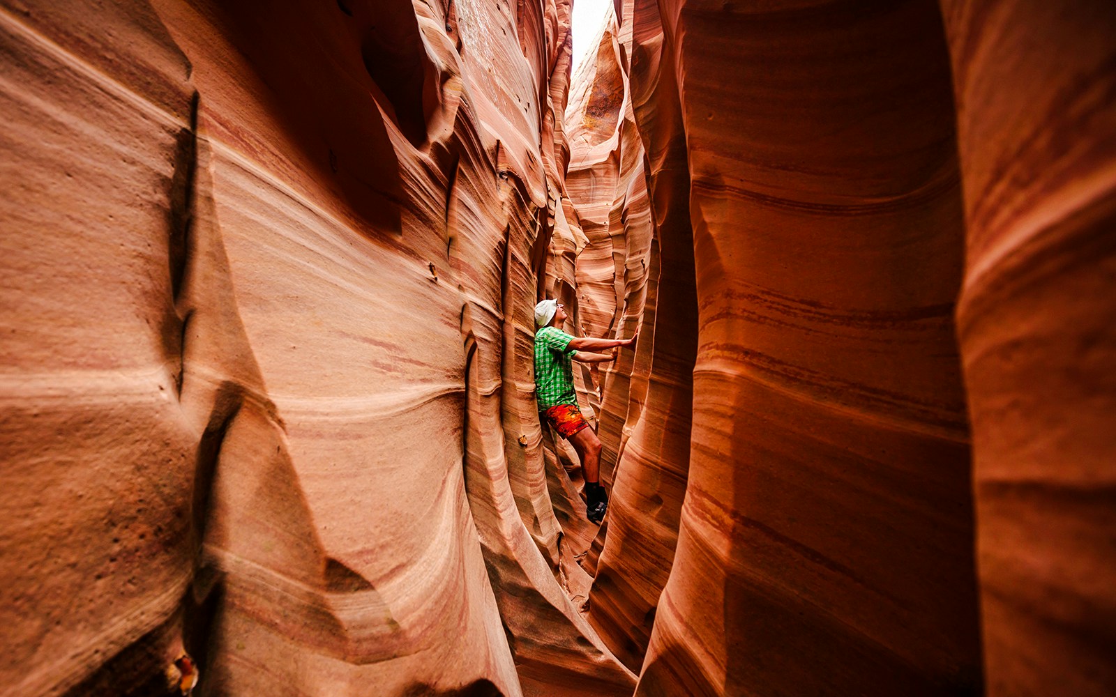 Person exploring narrow passage in Antelope Canyon, Arizona.