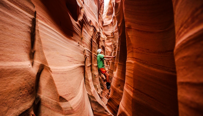 Person exploring narrow passage in Antelope Canyon, Arizona.