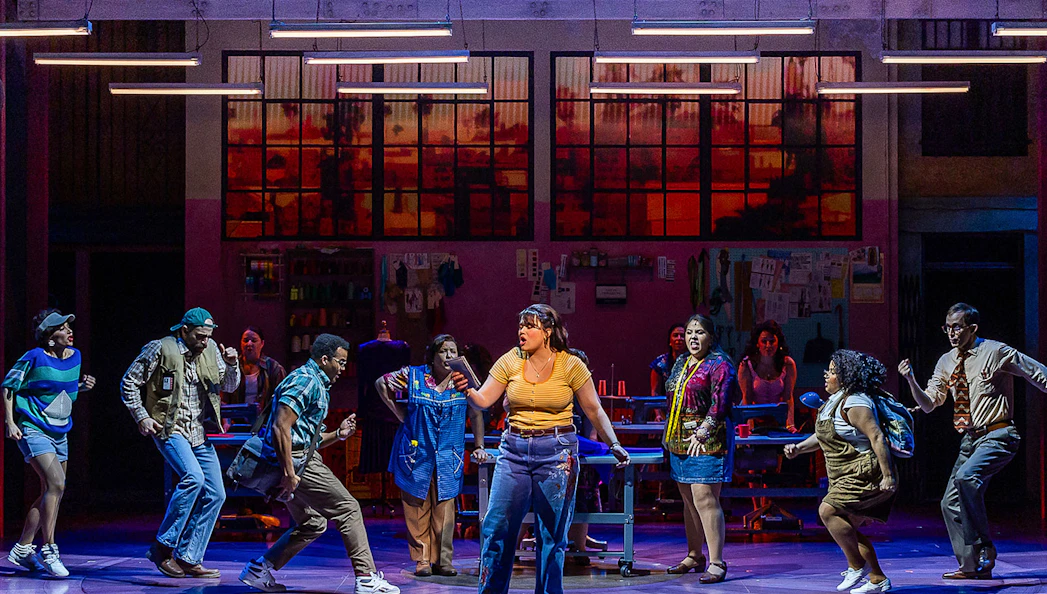 Cast performing a scene from "Real Women Have Curves: The Musical" on stage.