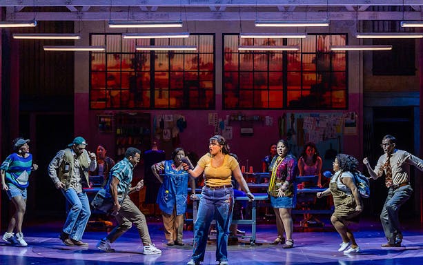 Cast performing a scene from "Real Women Have Curves: The Musical" on stage.