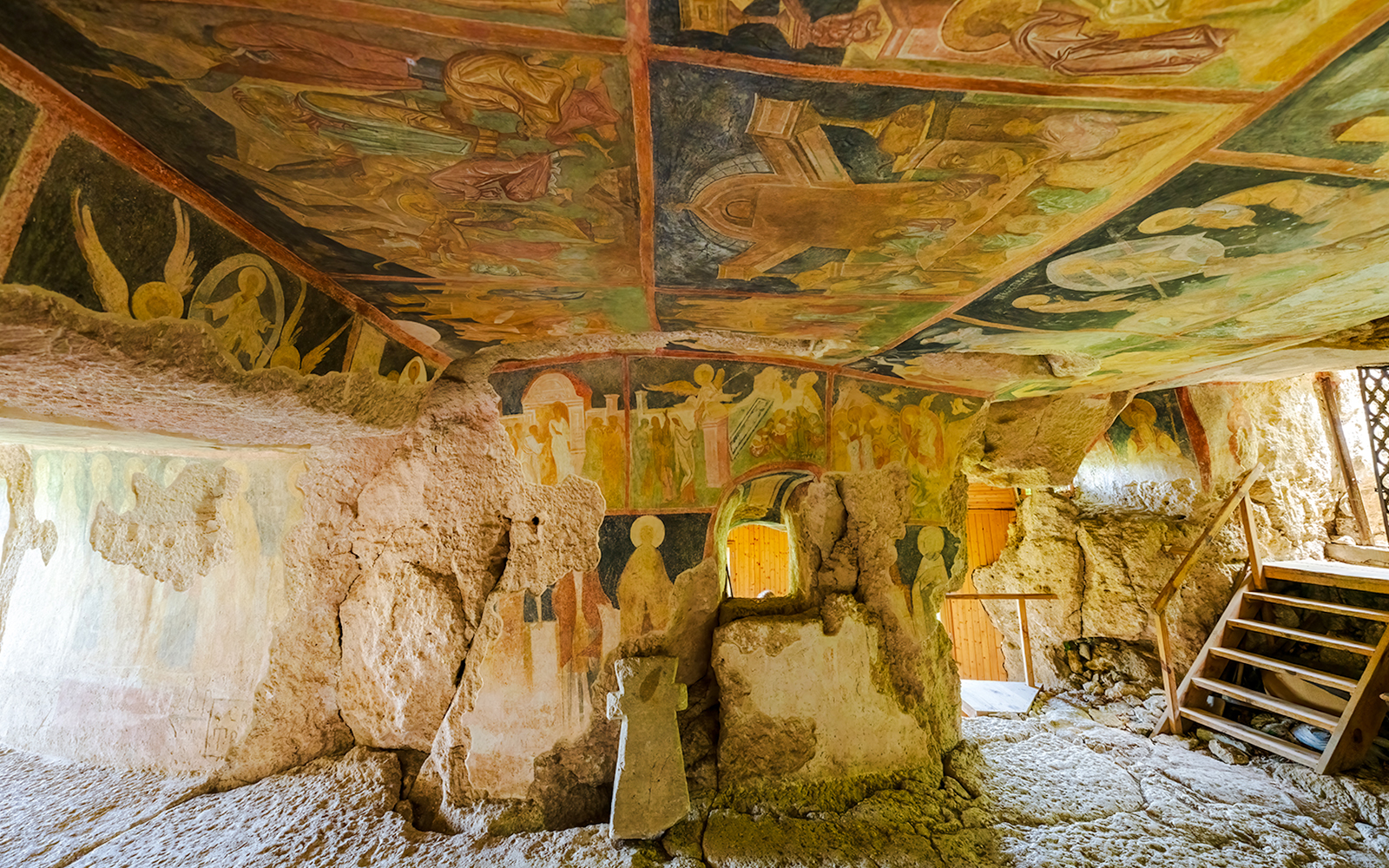 Frescoes inside the Rock Churches of Ivanovo, Bulgaria, depicting religious scenes on stone walls.