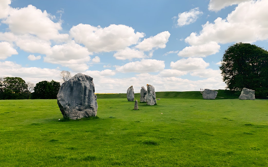 Avebury stone circle under a blue sky on a guided day tour from London.