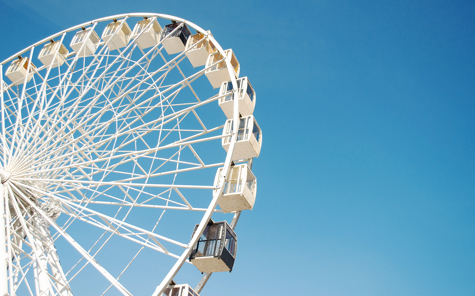 Ferris wheel against a clear blue sky.