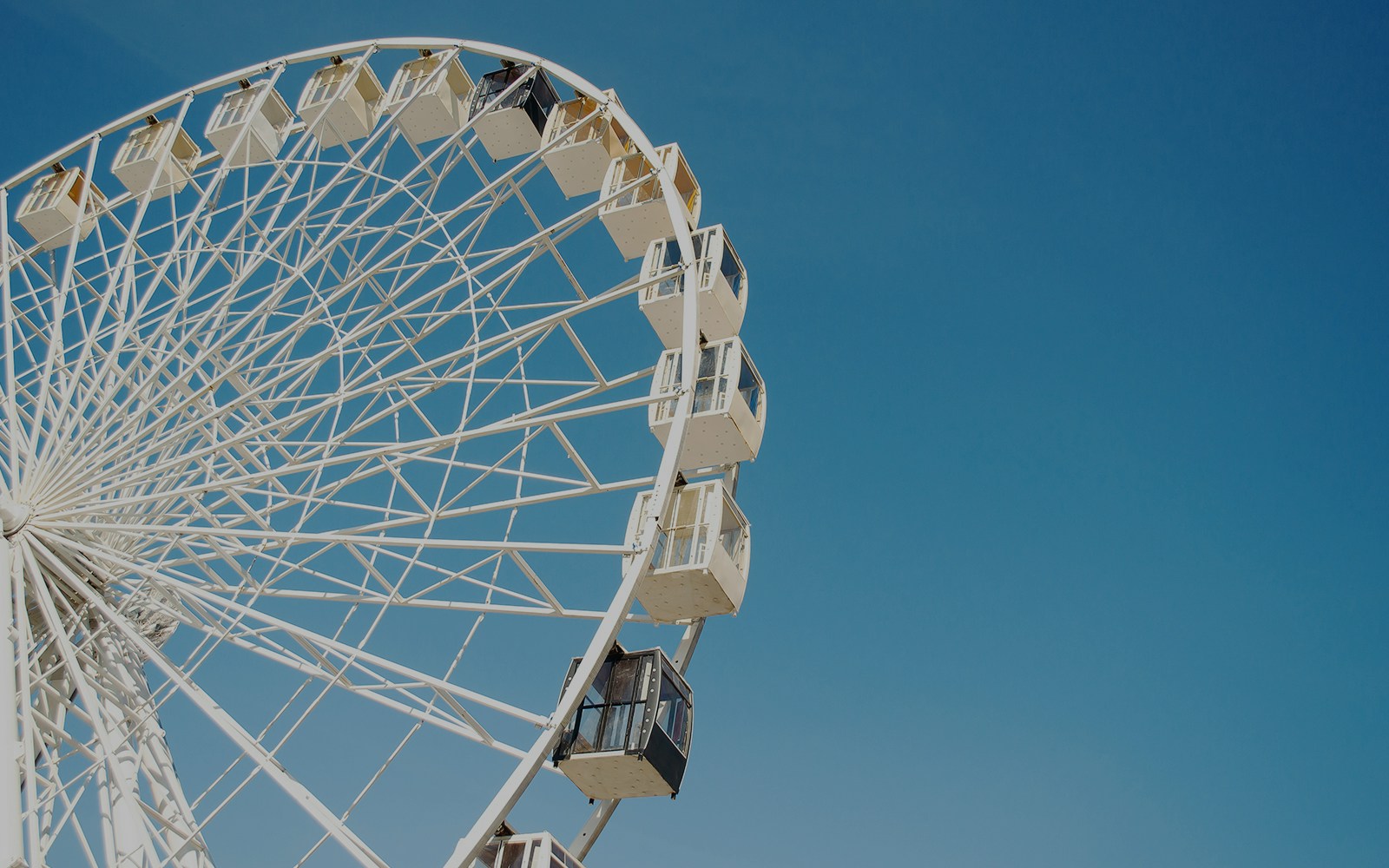 Ferris wheel against a clear blue sky.