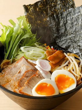 Bowl of ramen with soft-boiled eggs, pork slices, and vegetables at Tokyo cooking class.