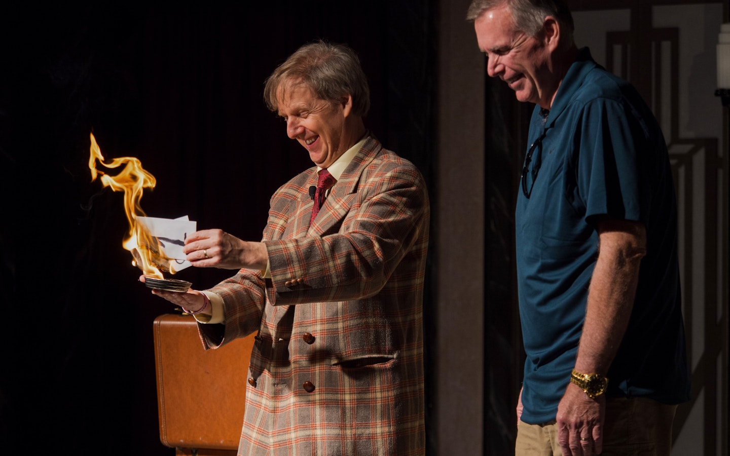 Magician performing fire trick with audience member at The Mac King Comedy Magic Show, Vegas.