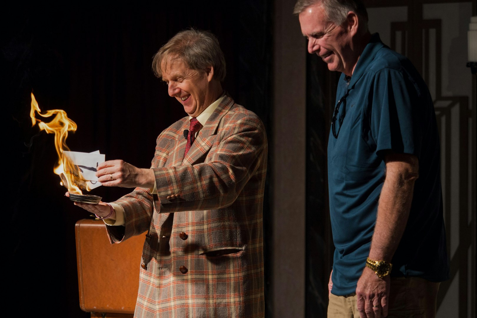 Magician performing fire trick with audience member at The Mac King Comedy Magic Show, Vegas.