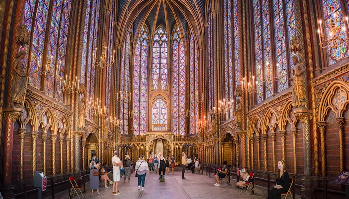 Visitors inside Sainte-Chapelle, Paris, admiring the stained glass windows.
