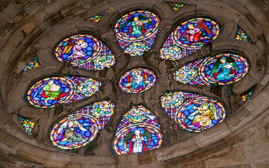 Stained glass window depicting religious figures in a church.