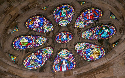Stained glass window depicting religious figures in a church.