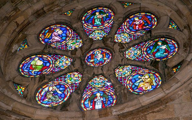 Stained glass window depicting religious figures in a church.