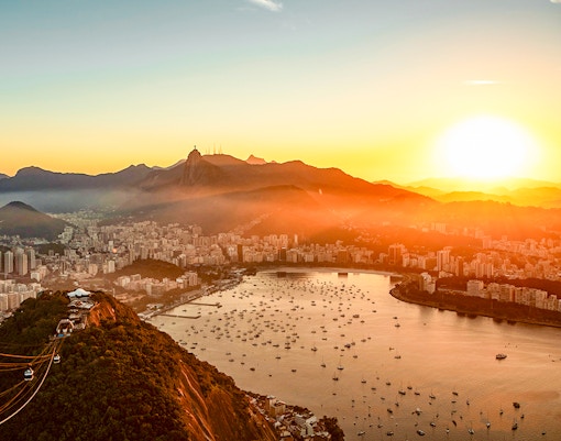 Panoramic aerial view of Guanabara Bay, Christ the Redeemer, and Sugarloaf Mountain at sunset, Rio de Janeiro.