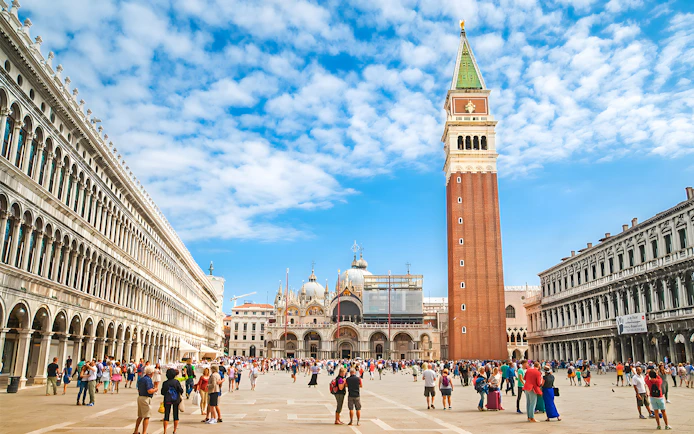 St. Mark's Square with Campanile and Basilica in Venice, Italy, crowded with tourists.