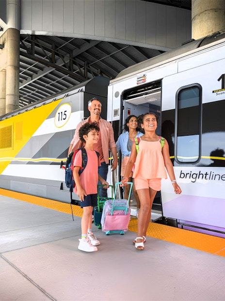 Family boarding Brightline train for Miami trip with open top bus and islands boat cruise.