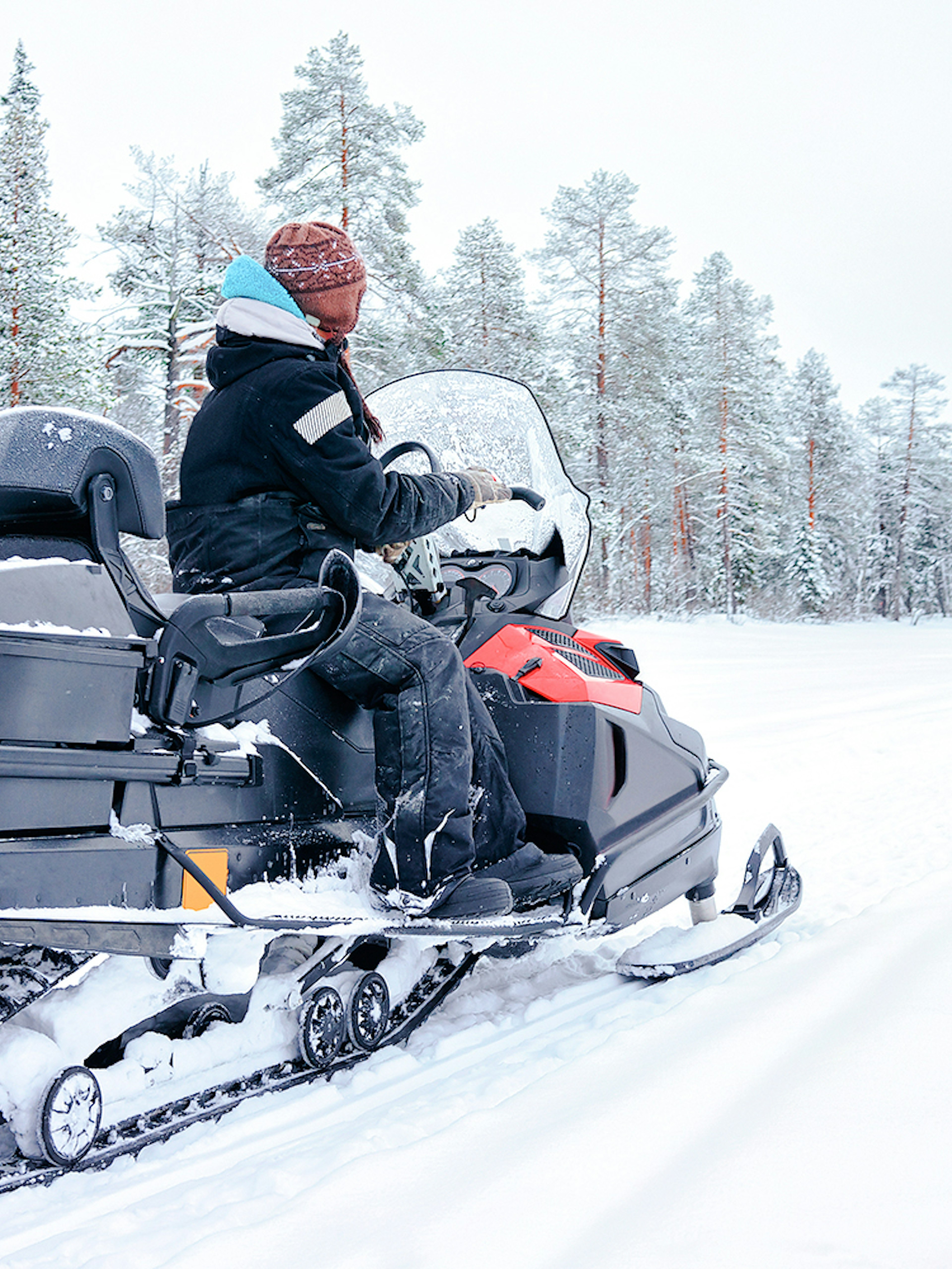 Woman riding snowmobile on a frozen lake in winter, Rovaniemi, Finland.