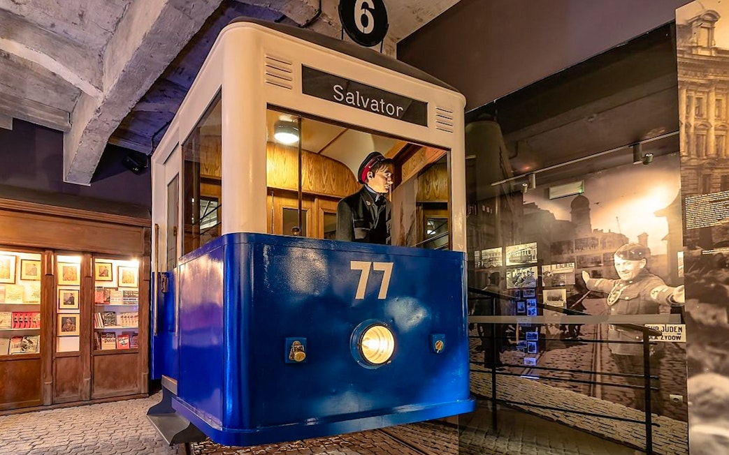 Tram exhibit at Oskar Schindler's Factory museum, Krakow, with historical photos.