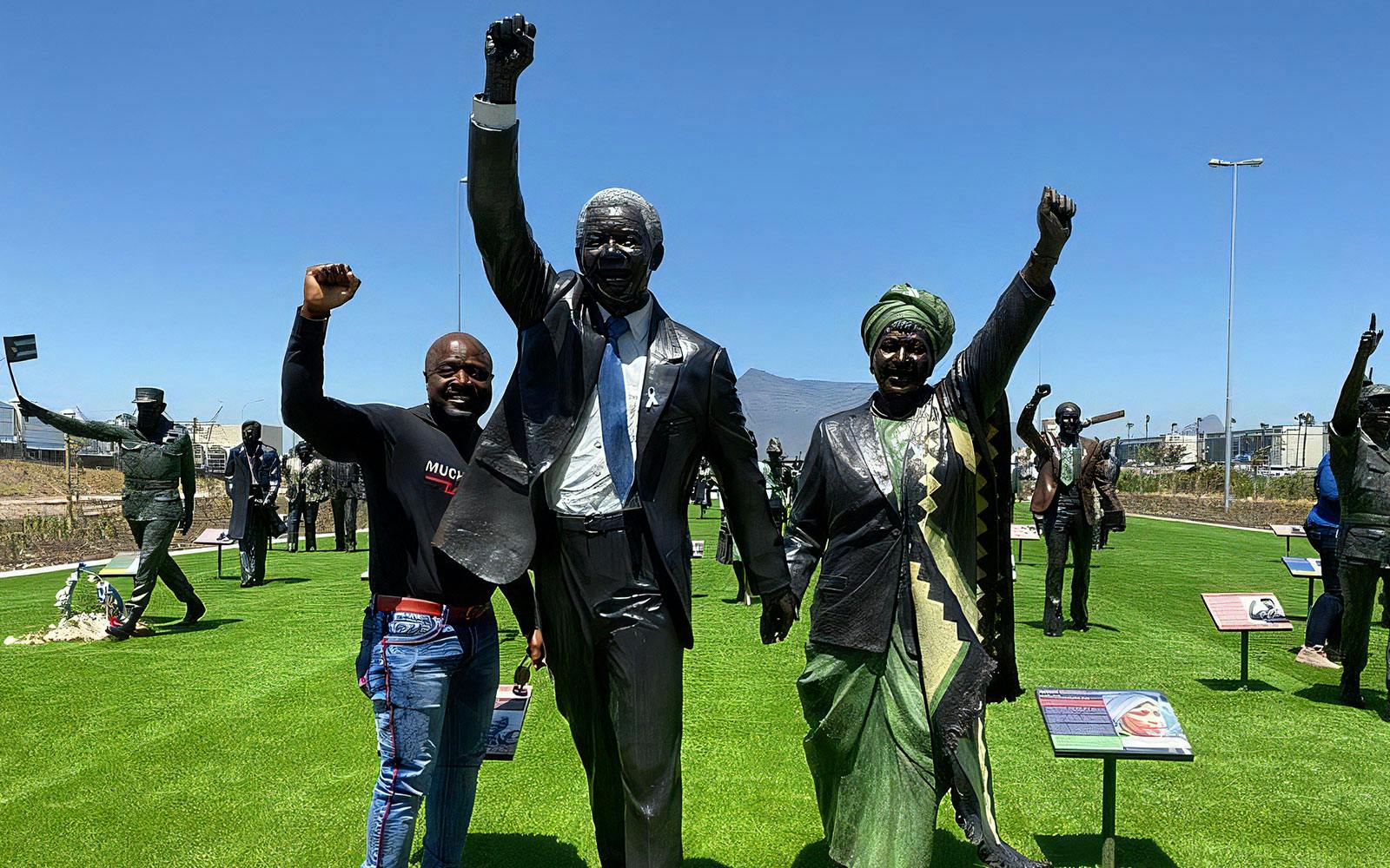 Tourist with Nelson Mandela statue at Robben Island, South Africa.