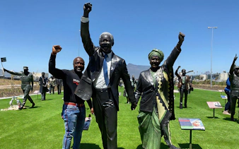 Tourist with Nelson Mandela statue at Robben Island, South Africa.