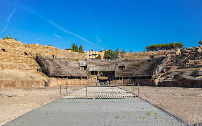 Flavian Amphitheater in Pozzuoli with ancient stone seating and central arena.
