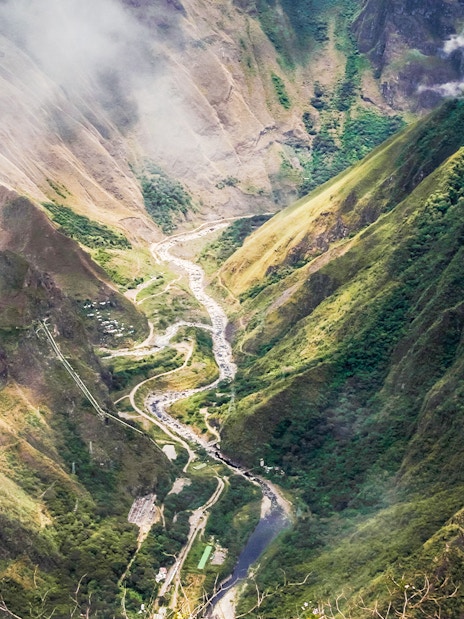 Panoramic view of Vilcanota Valley with winding river and lush green mountains.