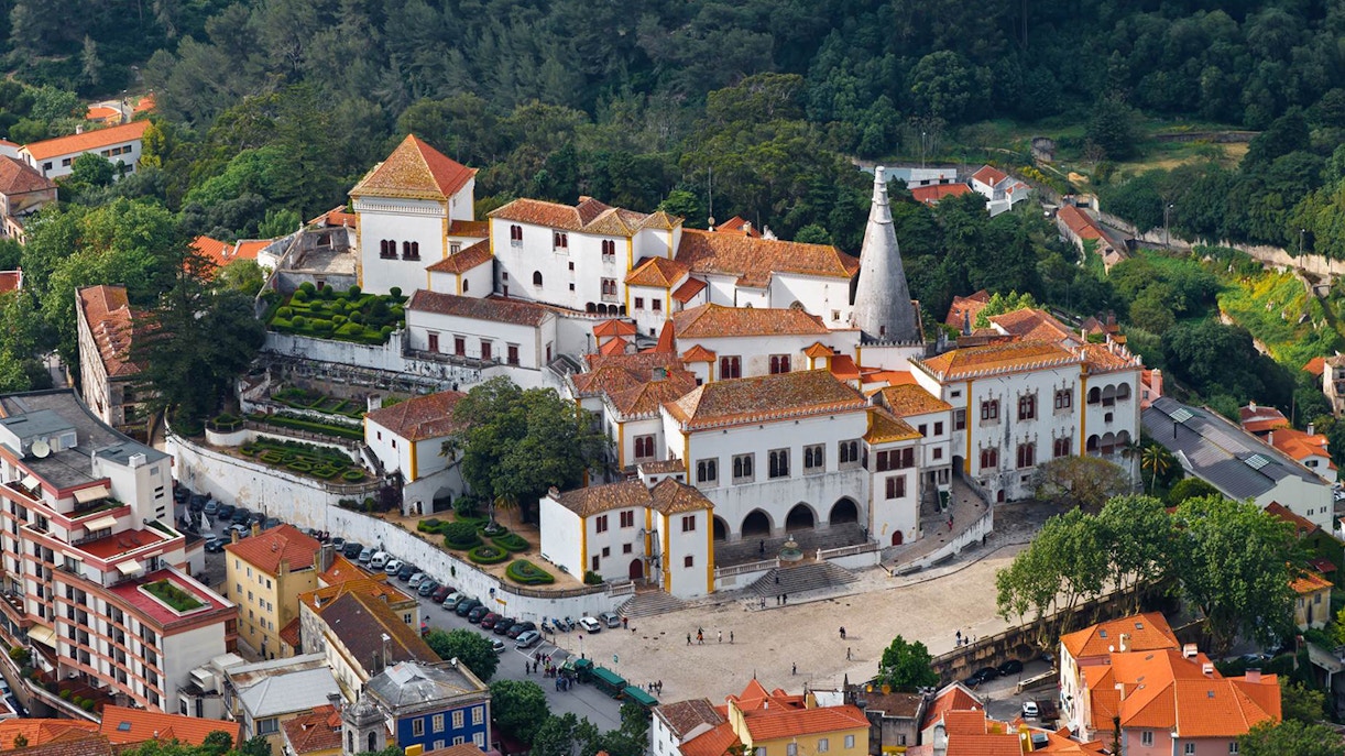 National Palace of Sintra with red-tiled roofs and surrounding greenery in Lisbon, Portugal.