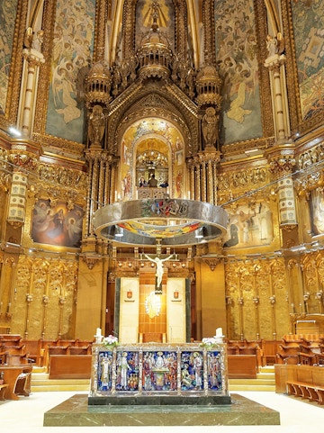 Monserrat Monastery altar with ornate gold detailing and religious artwork.