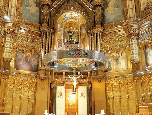 Monserrat Monastery altar with ornate gold detailing and religious artwork.