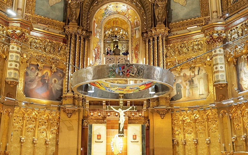 Monserrat Monastery altar with ornate gold detailing and religious artwork.