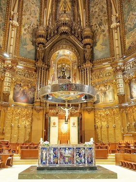 Monserrat Monastery altar with ornate gold detailing and religious artwork.