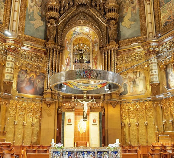 Monserrat Monastery altar with ornate gold detailing and religious artwork.