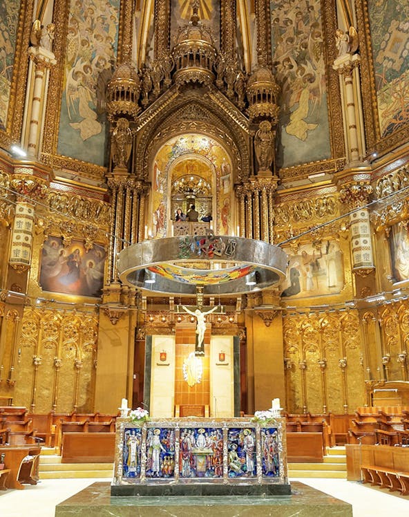 Monserrat Monastery altar with ornate gold detailing and religious artwork.