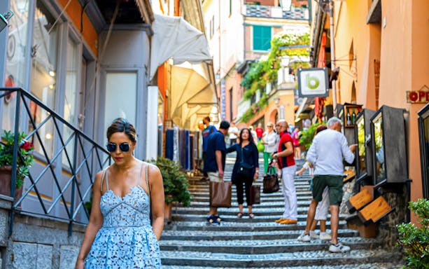 Pedestrians walking through a vibrant street in Bellagio, Lake Como, Italy.