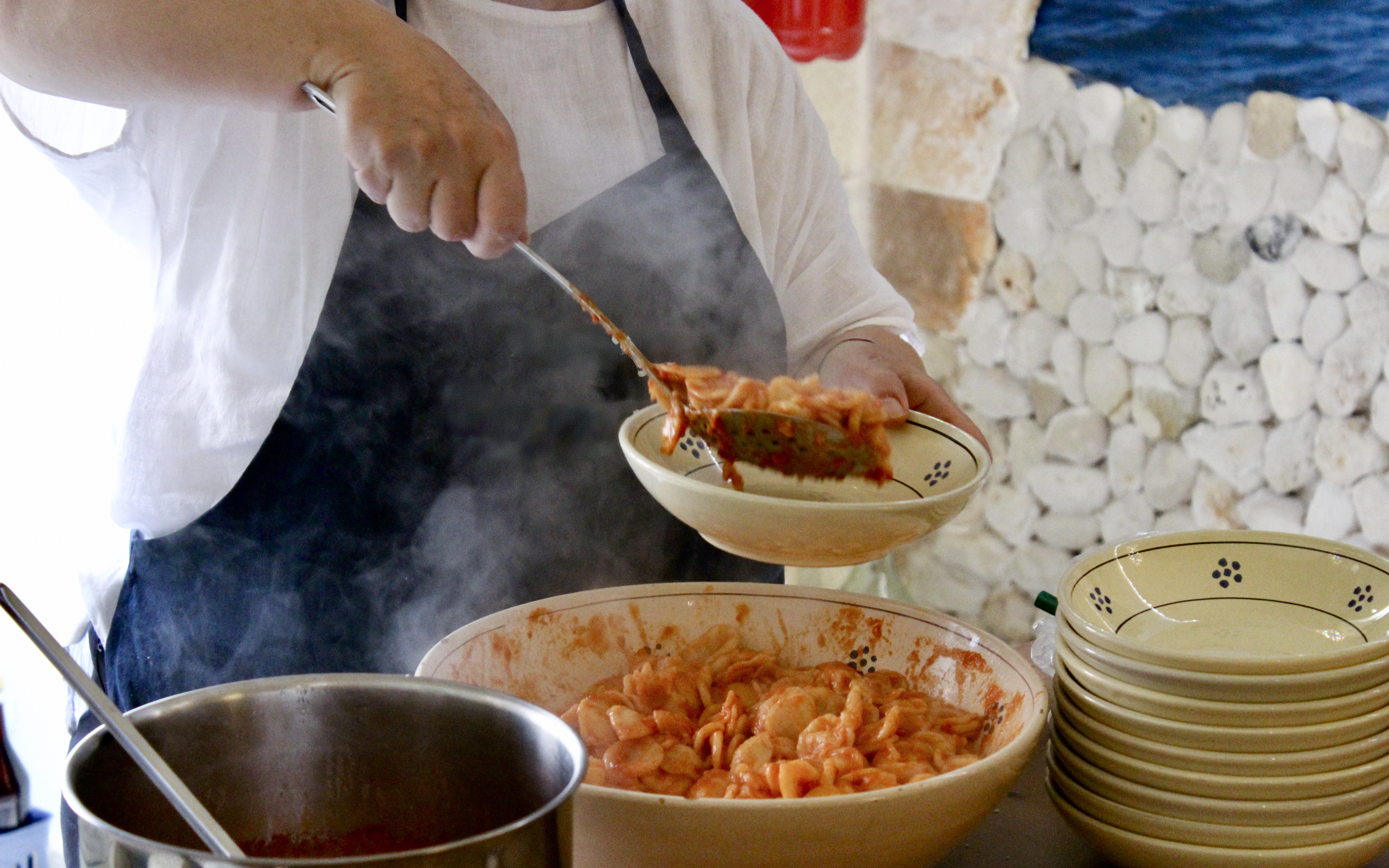Serving pasta at Polignano a Mare cooking class.