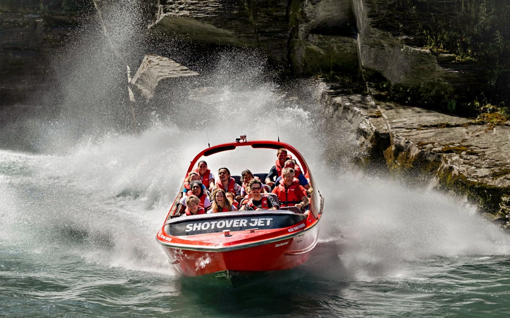 Shotover Jet boat navigating through narrow canyon waters.