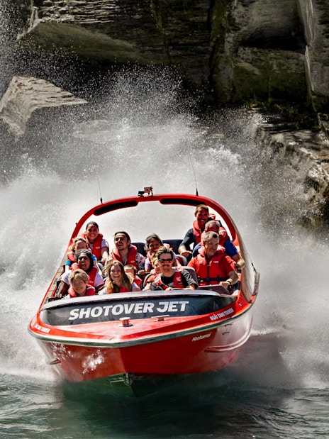 Shotover Jet boat navigating through narrow canyon waters.