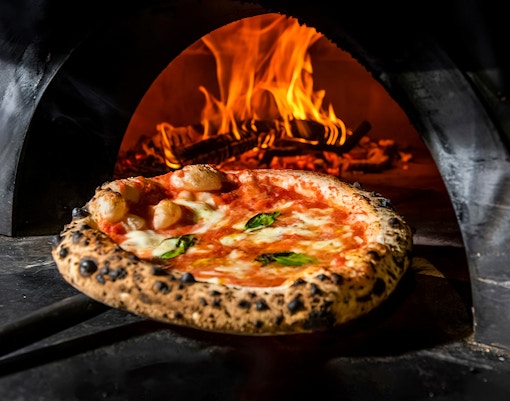 Neapolitan pizza with fresh basil and mozzarella in Naples, Italy.
