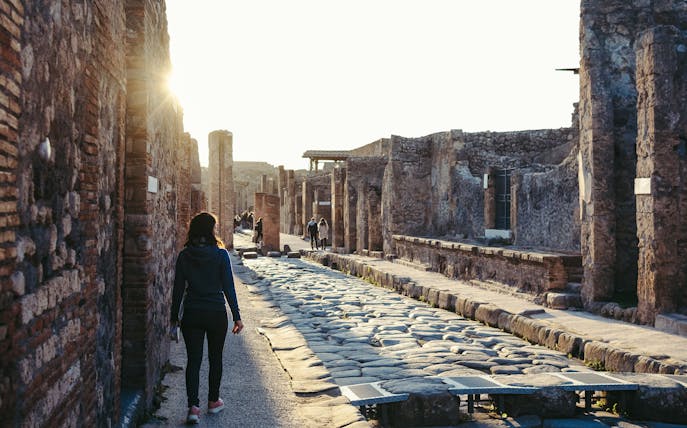 Guest walking through ancient streets of Pompeii, Italy.