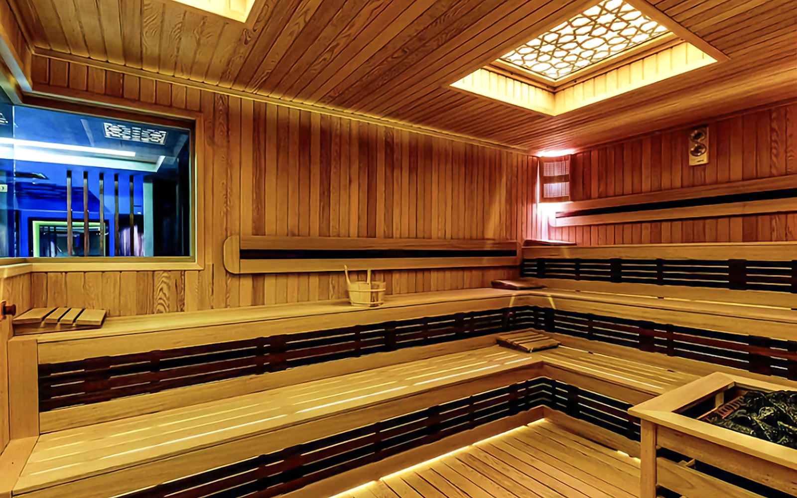 Interior of a wooden Turkish bath with benches and a central heating area.
