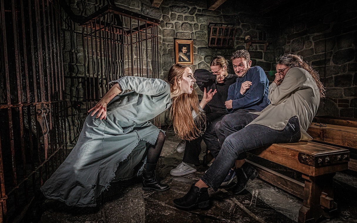 Witch scaring visitors at Berlin Dungeon attraction.