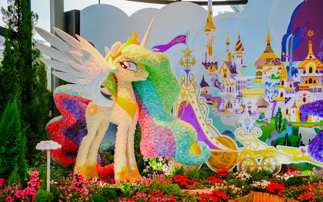 My Little Pony floral sculpture at Gardens by the Bay, Singapore, with fantasy castle backdrop.
