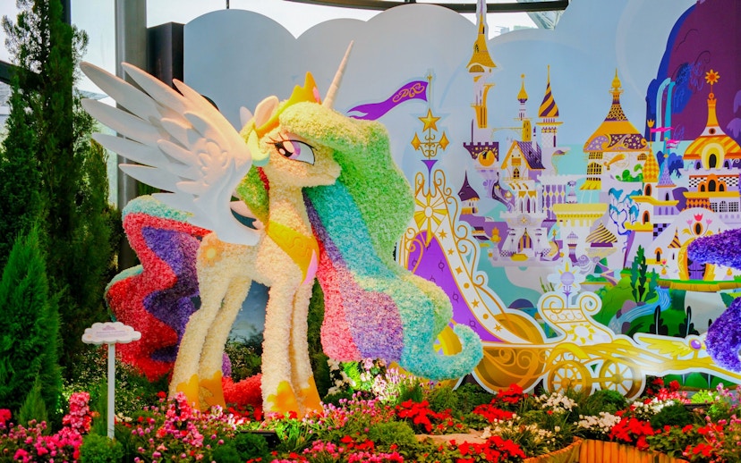 My Little Pony floral sculpture at Gardens by the Bay, Singapore, with fantasy castle backdrop.