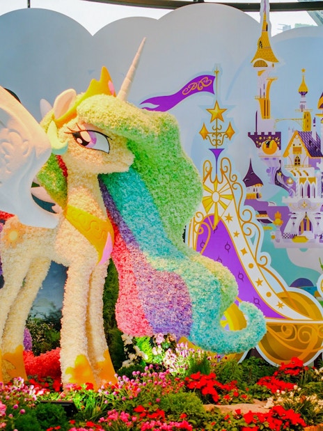 My Little Pony floral sculpture at Gardens by the Bay, Singapore, with fantasy castle backdrop.