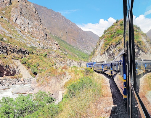 Train traveling through Andes mountains from Ollantaytambo to Machu Picchu pueblo.