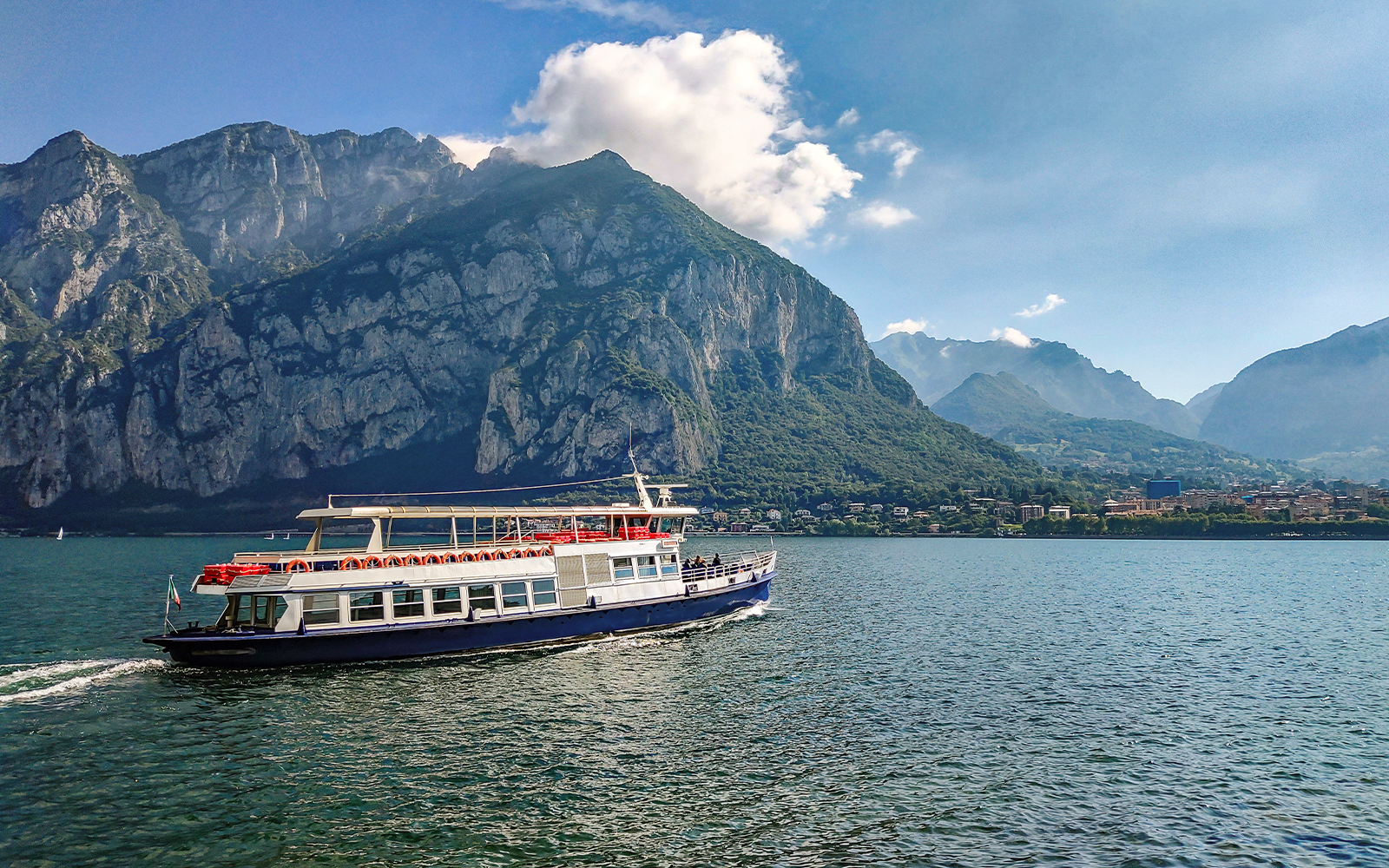 Ferry crossing Lake Como with mountains in the background, Italy.
