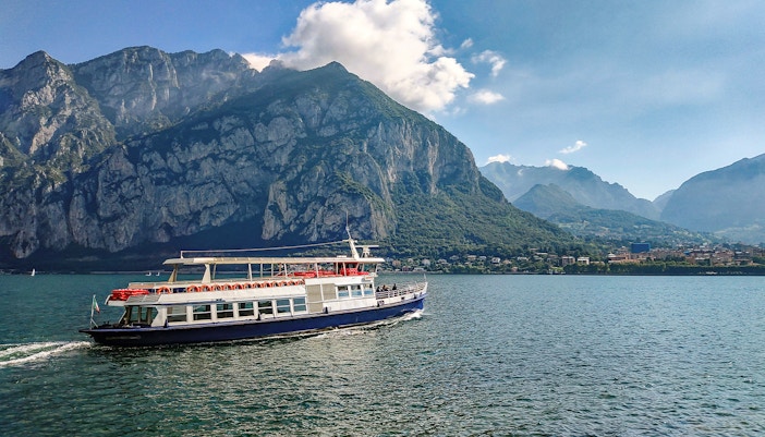 Ferry crossing Lake Como with mountains in the background, Italy.