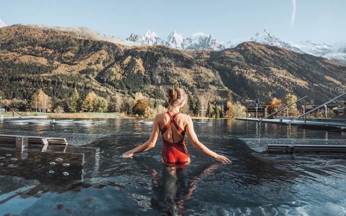 Visitor enjoying thermal baths at QC Terme Chamonix with mountain view.