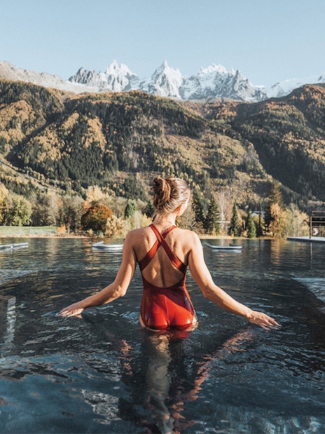 Visitor enjoying thermal baths at QC Terme Chamonix with mountain view.