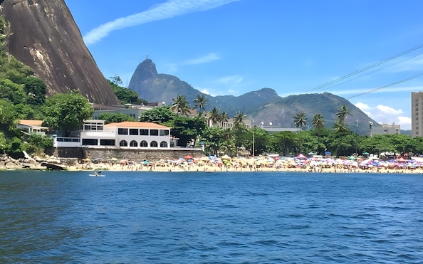 Rio de Janeiro beach with Sugarloaf Mountain and Christ the Redeemer in the background.
