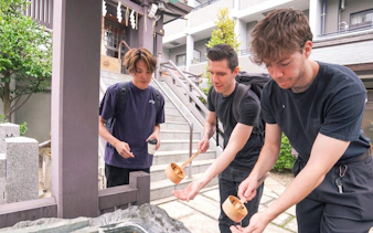 Visitors performing a purification ritual at a Tokyo shrine during a Samurai experience tour.