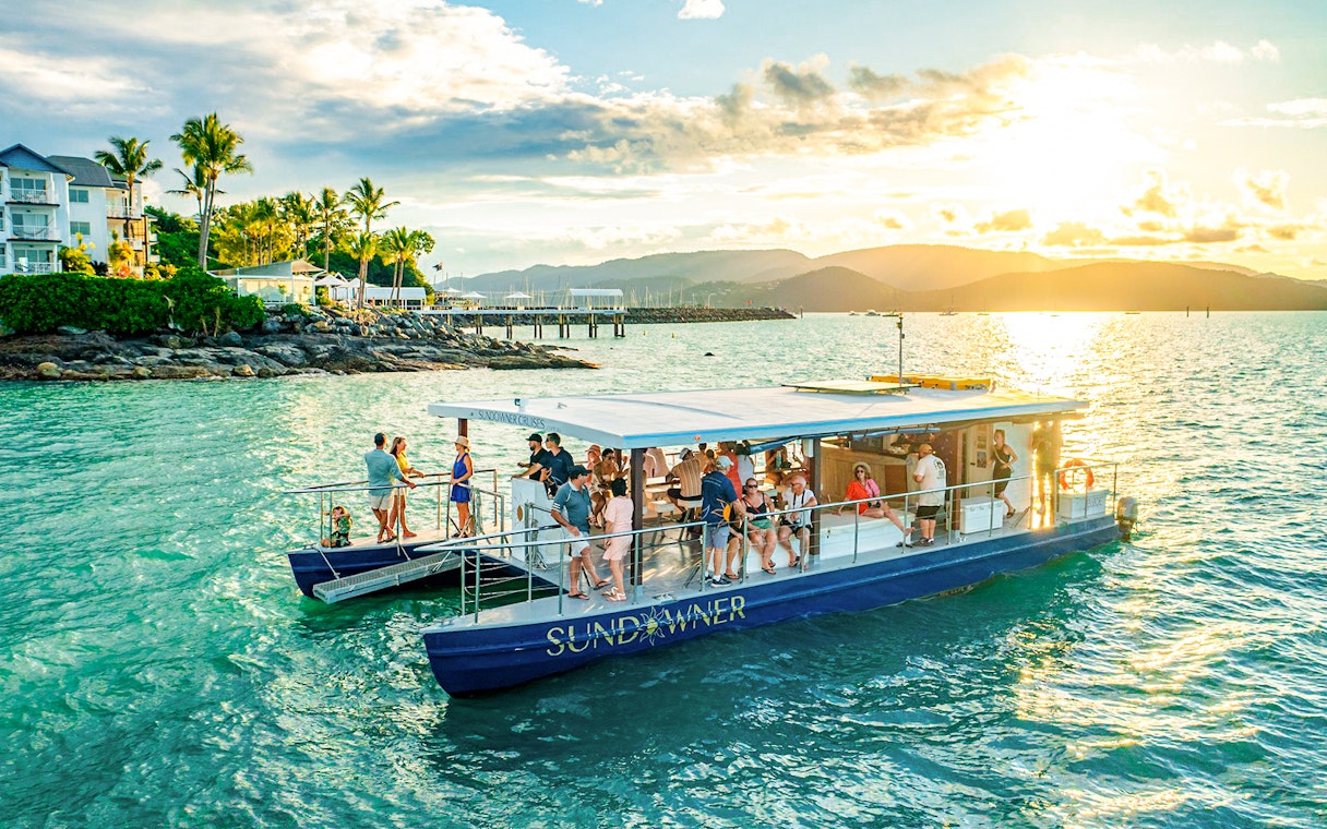 Sundowner cruise with people enjoying sunset near Airlie Beach.